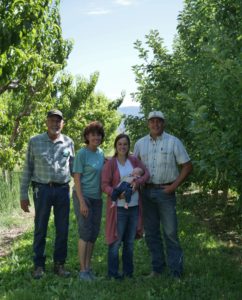 Lee, Kathy, Kendal, Beau, and Ryan Bradley standing in their orchard. 